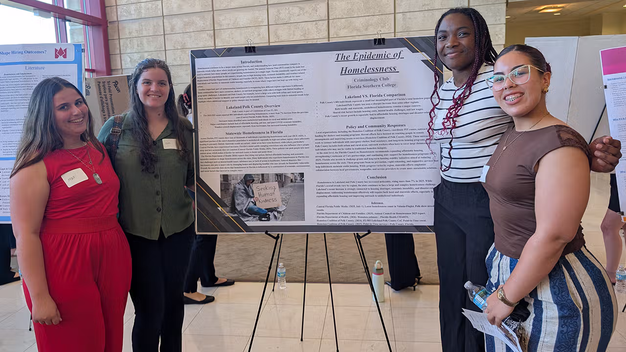 students standing in front of their research presentation