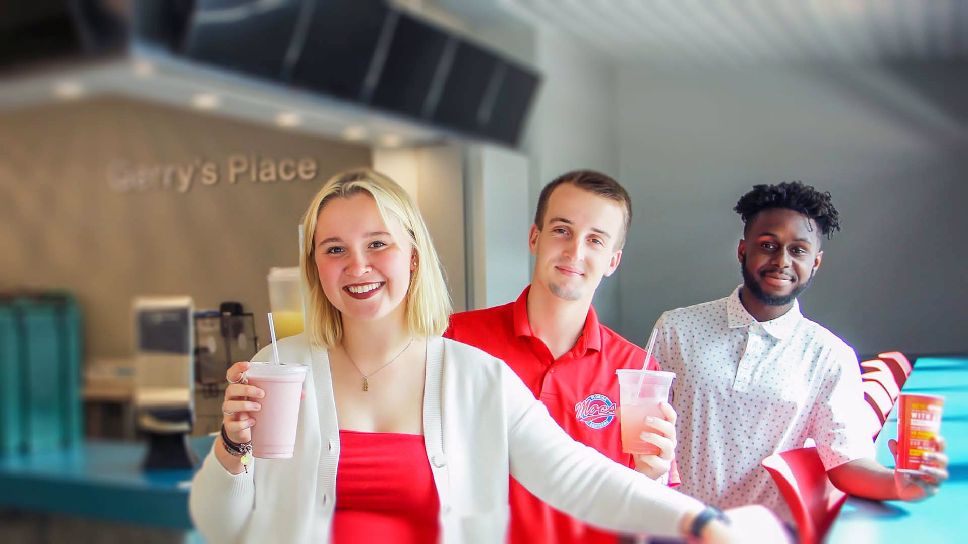 Students holding beverages in dining hall