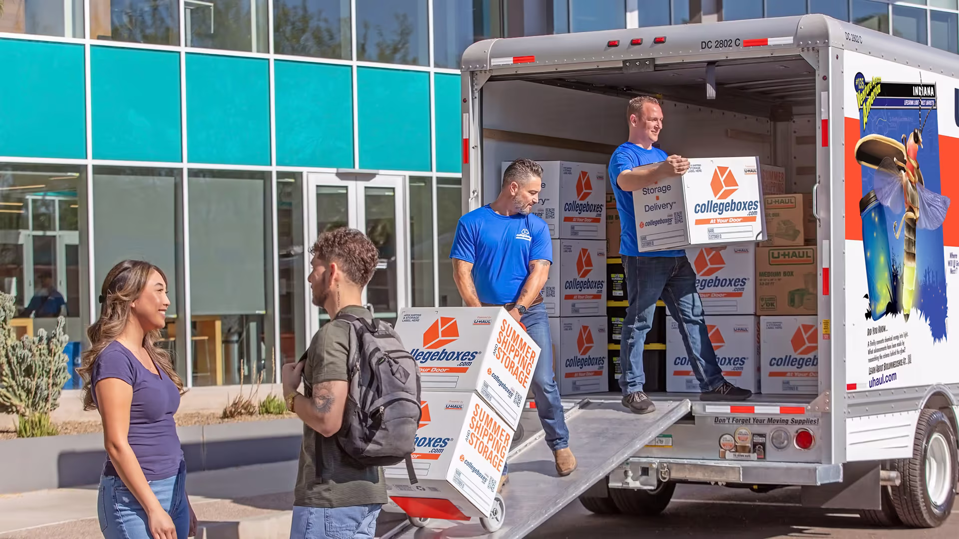 Movers with collegeboxes loading moving truck