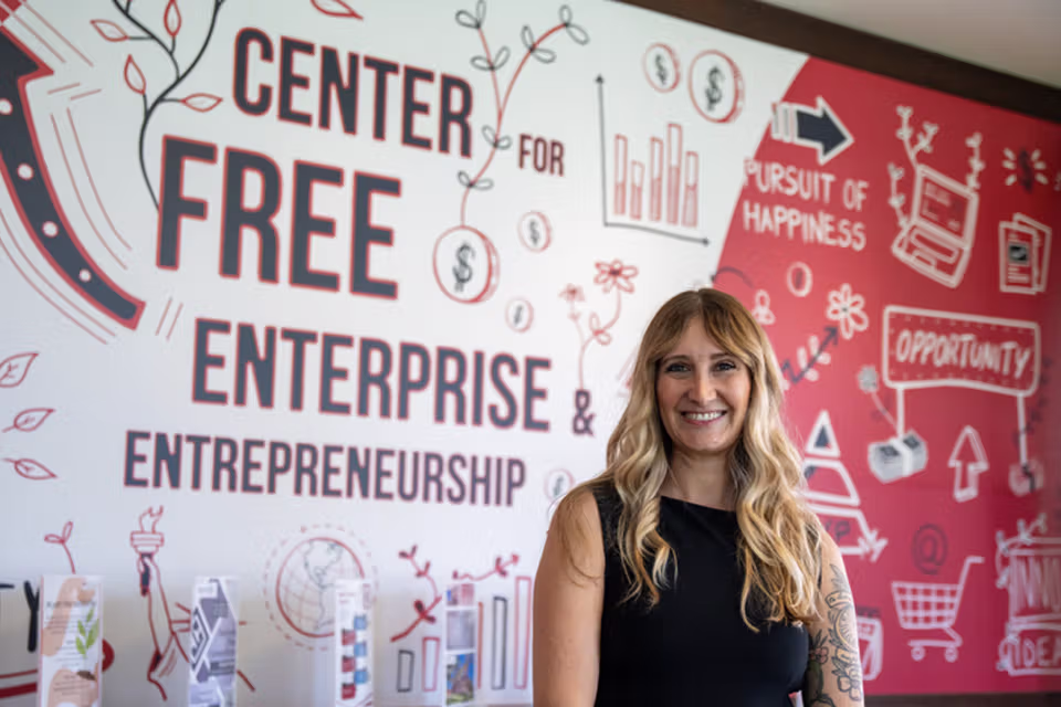 Student in front of the Center for Free Enterprise and Entrepreneurship mural on wall