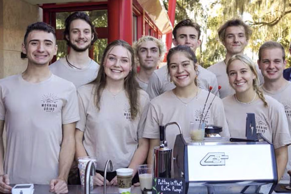 student entrepreneurs standing behind the morning grind coffee cart