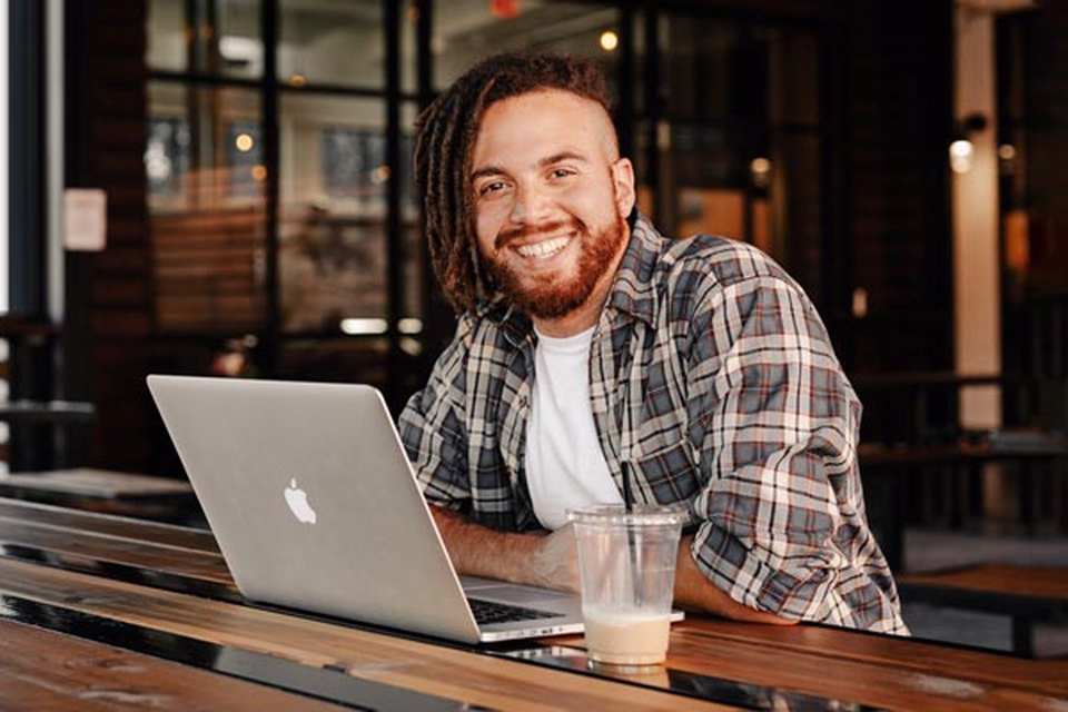 Man with coffee cup using laptop