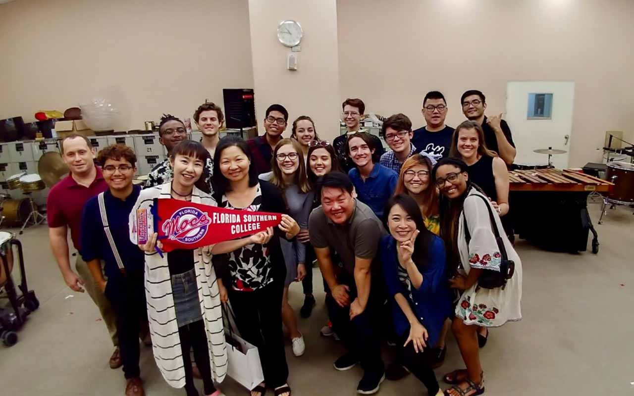 Chen holding up an FSC banner surrounded by her students