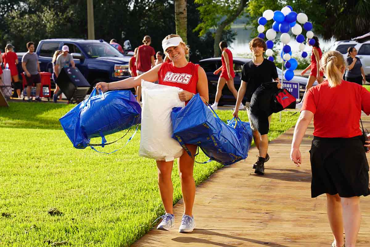 Student carrying their bags into their dorm