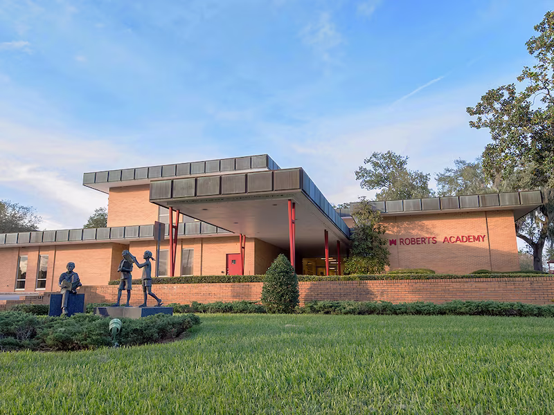 Exterior photo of the Roberts Academy building with a clear blue sky.