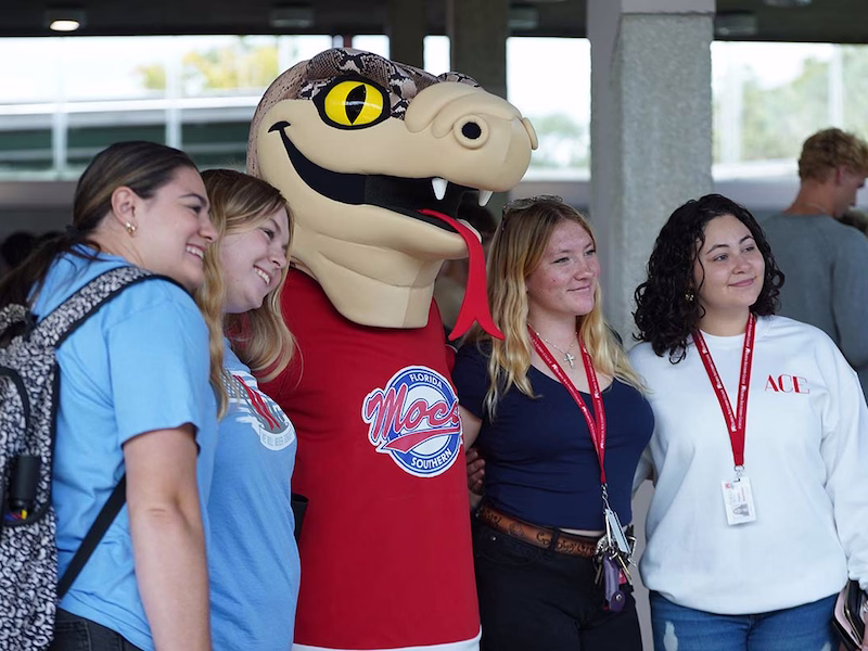 Mocsie posing with four students