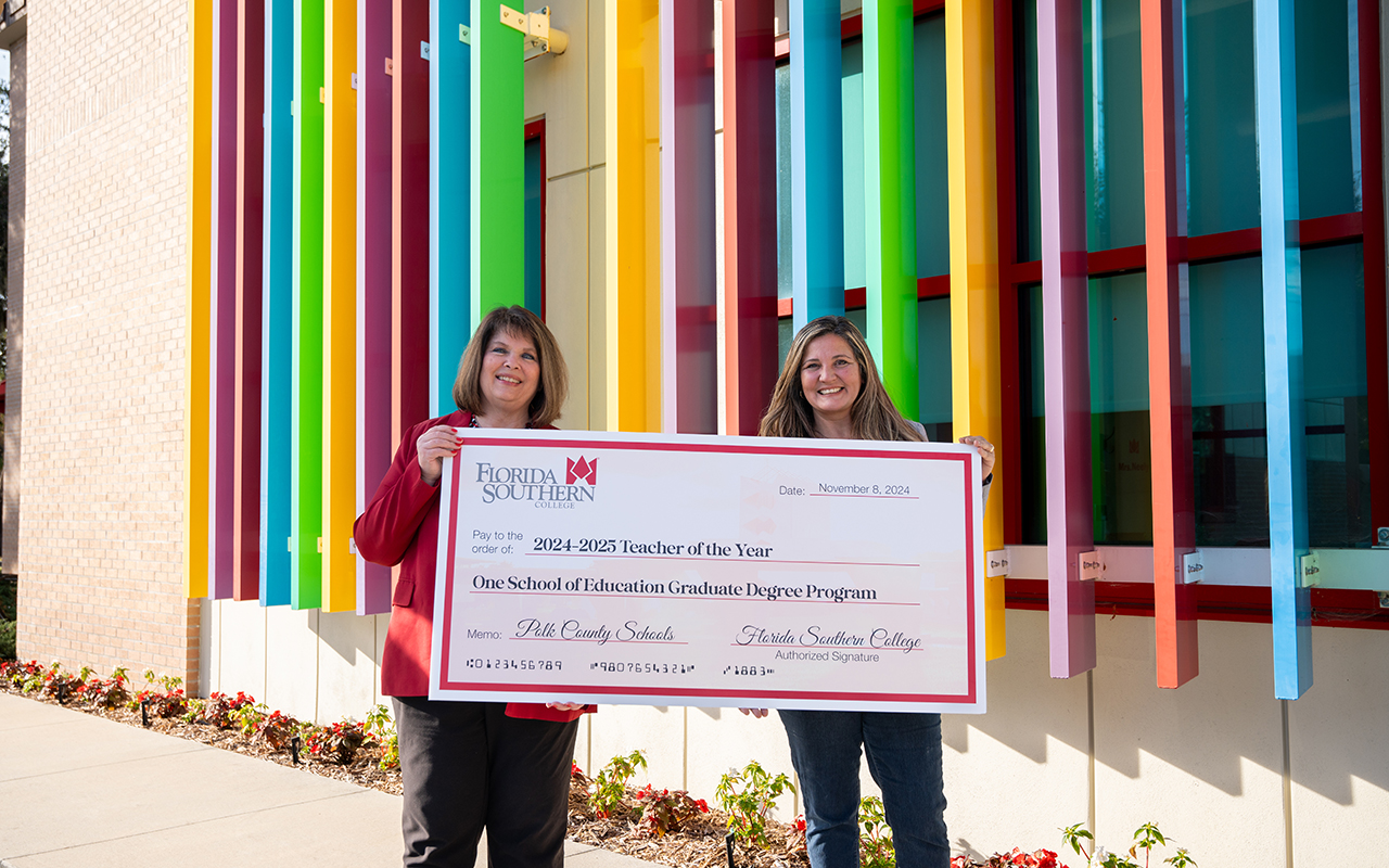 Cynara Appling and Dr. Rakes holding a large check for 