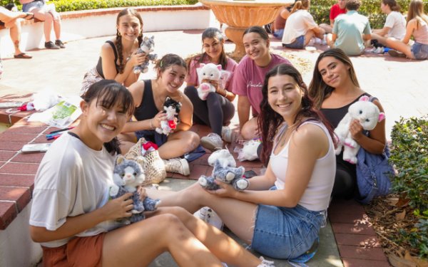 students with their campus cat stuffed animals