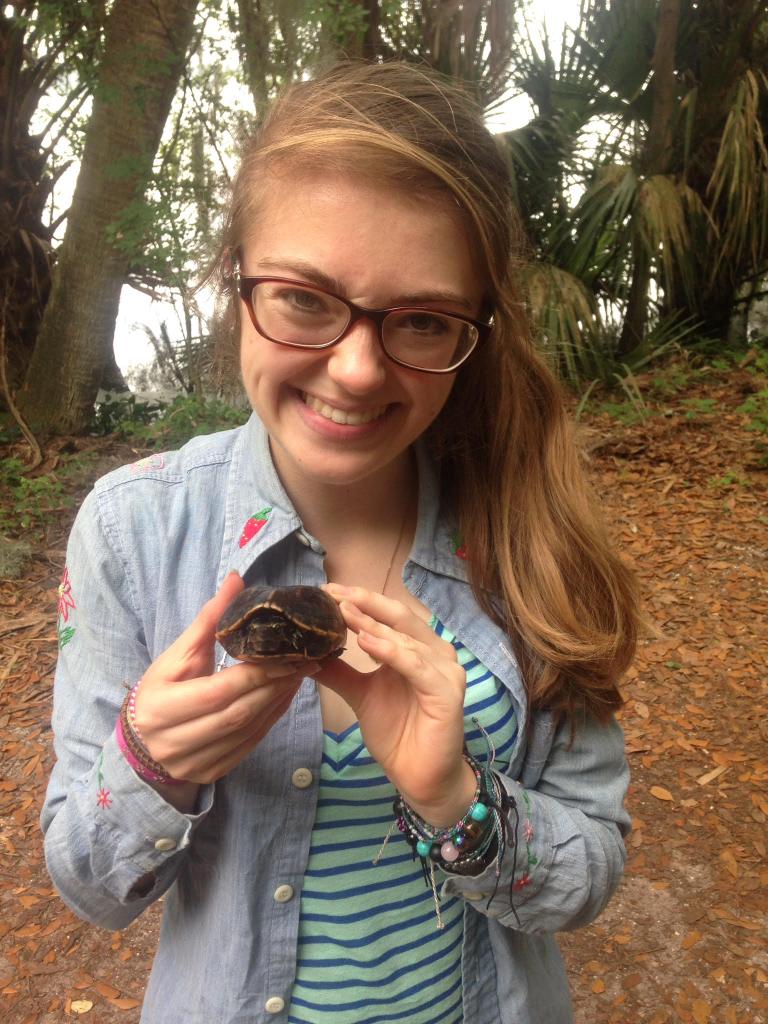 Leyna posing with a mud turtle, the subject of her research at FSC.
