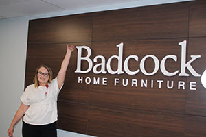 Rachael Buckel '21 in front of the Badcock & More Home Furniture Sign.