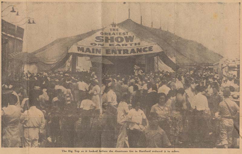 A circus tent with a huge crowd of people. Caption reads: The Big Top as it looked before the disastrous fire in Hartford reduced it to ashes.