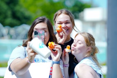 Three Students taking a selfie with prizes at Frank Lloyd Wright Day at Florida Southern College.