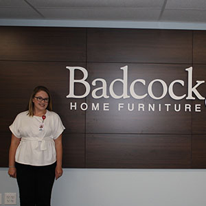 Rachael Buckel '21 in front of the Badcock & More Home Furniture Sign.