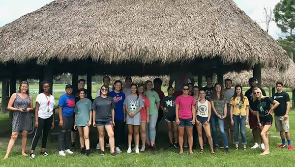 students under a tiki hut