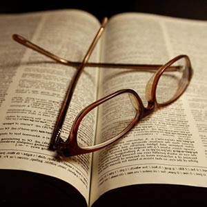 Glasses laying  on a book.