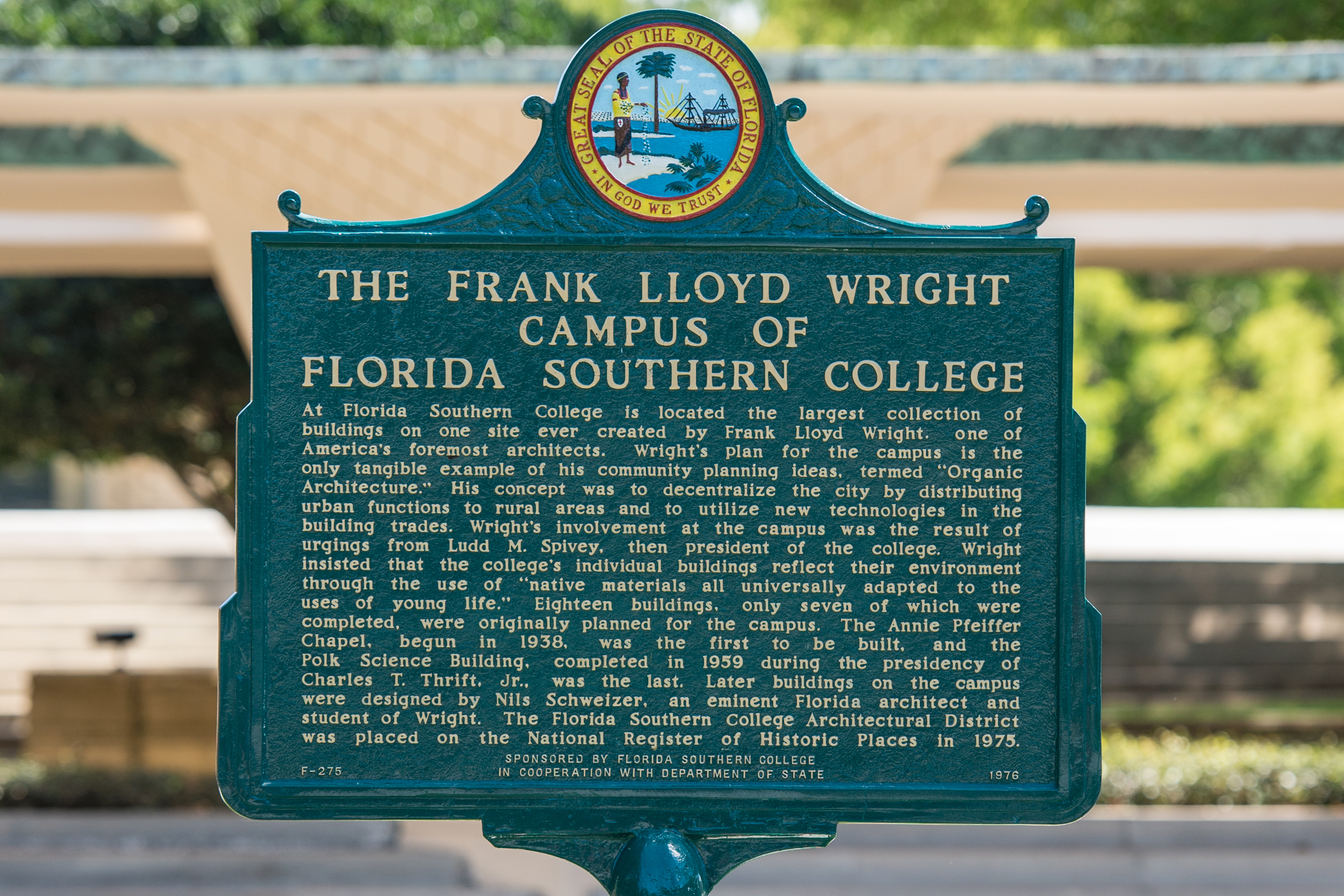 The Frank Lloyd Wright Campus of Florida Southern College. At Florida Southern College is located the largest collection of buildings on one site ever created by Frank Lloyd Wright. one of America's foremost architects. Wright's plan for the campus is the only tangible example of his community planning ideas, termed "Organic Architecture." His concept was to decentralize the city by distributing urban functions to rural areas and to utilize new technologies in the building trades. Wright's involvement at the campus was the result of urgings from Ludd M. Spivey, then president of the college. Wright insisted that the college's individual buildings reflect their environment through the use of "native materials all universally adapted to the uses of young life." Eighteen buildings, only seven of which were completed, were originally planned for the campus. The Annie Pfeiffer Chapel, begun in 1938, was the first to be built, and the Polk Science Building, completed in 1959 during the presidency of Charles T. Thrift, Jr., was the last. Later buildings on the campus were designed by Nils Schweizer, an eminent Florida architect and student of Wright. The Florida Southern College Architectural District was placed on the National Register of Historic Places in 1975. Sponsored By Florida Southern College in Cooperation with Department of State. F-275. 1976.